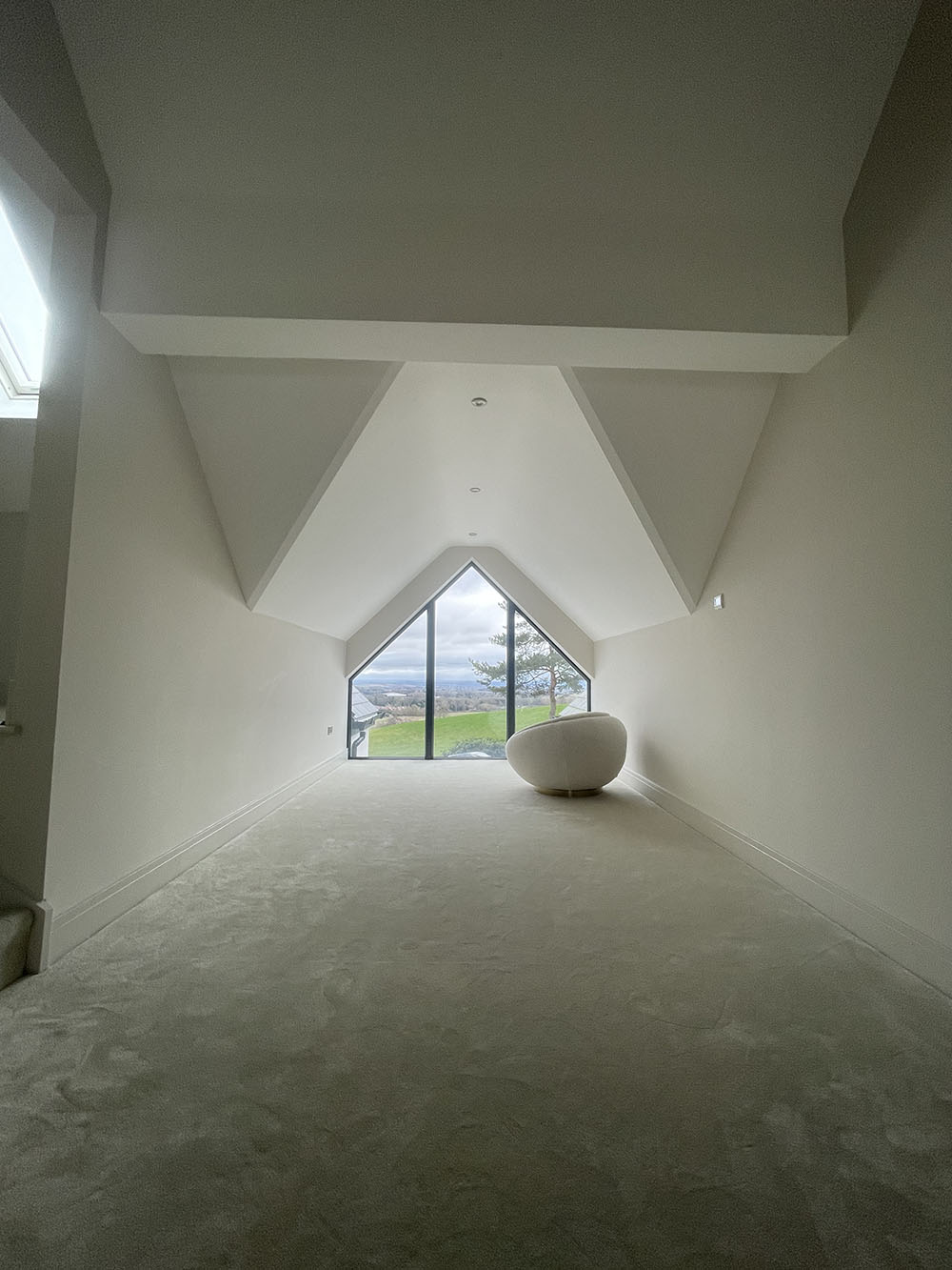 Angled ceilings in a room with a large triangular window