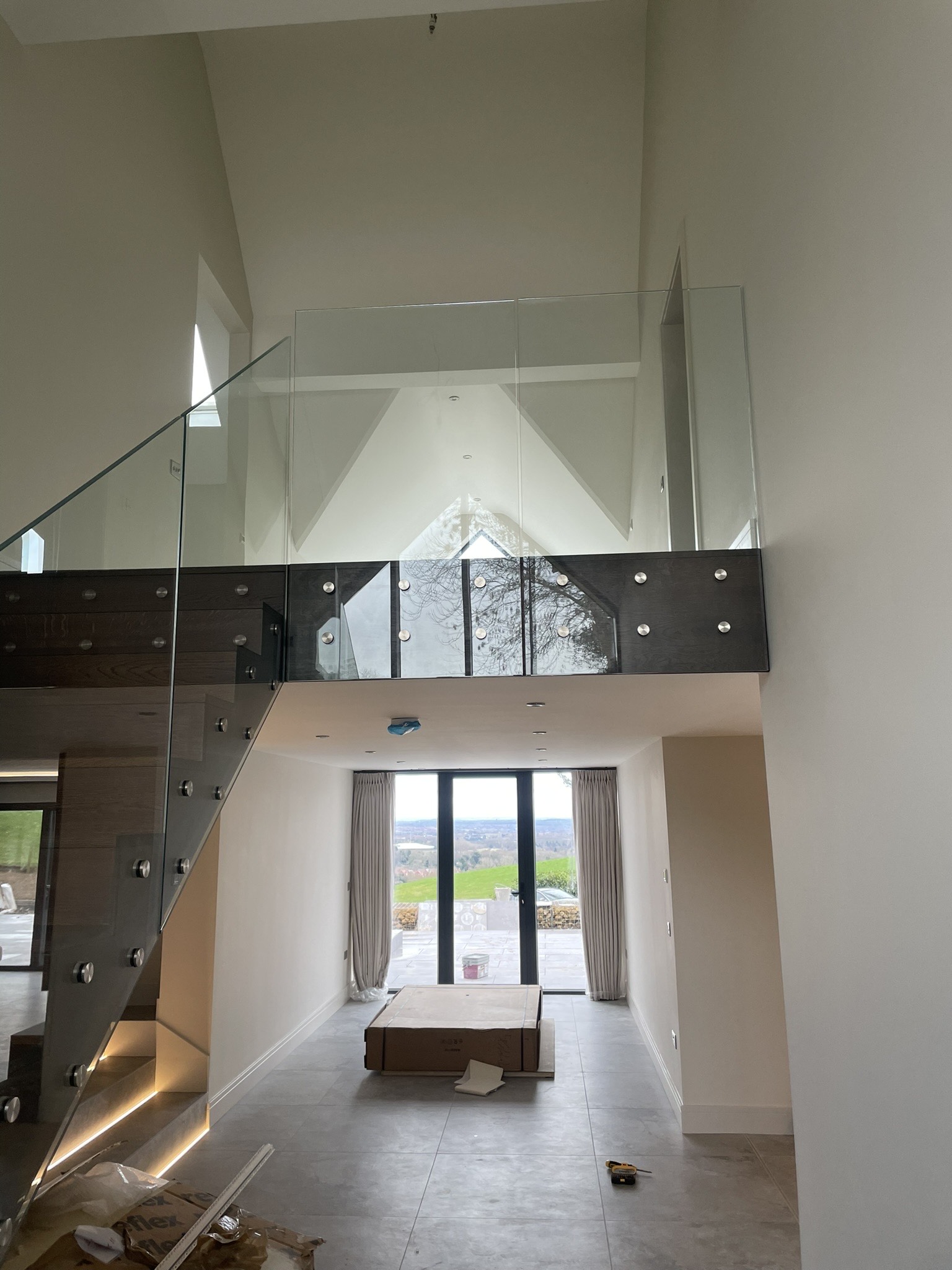 Entrance of a home with large windows and a glass staircase